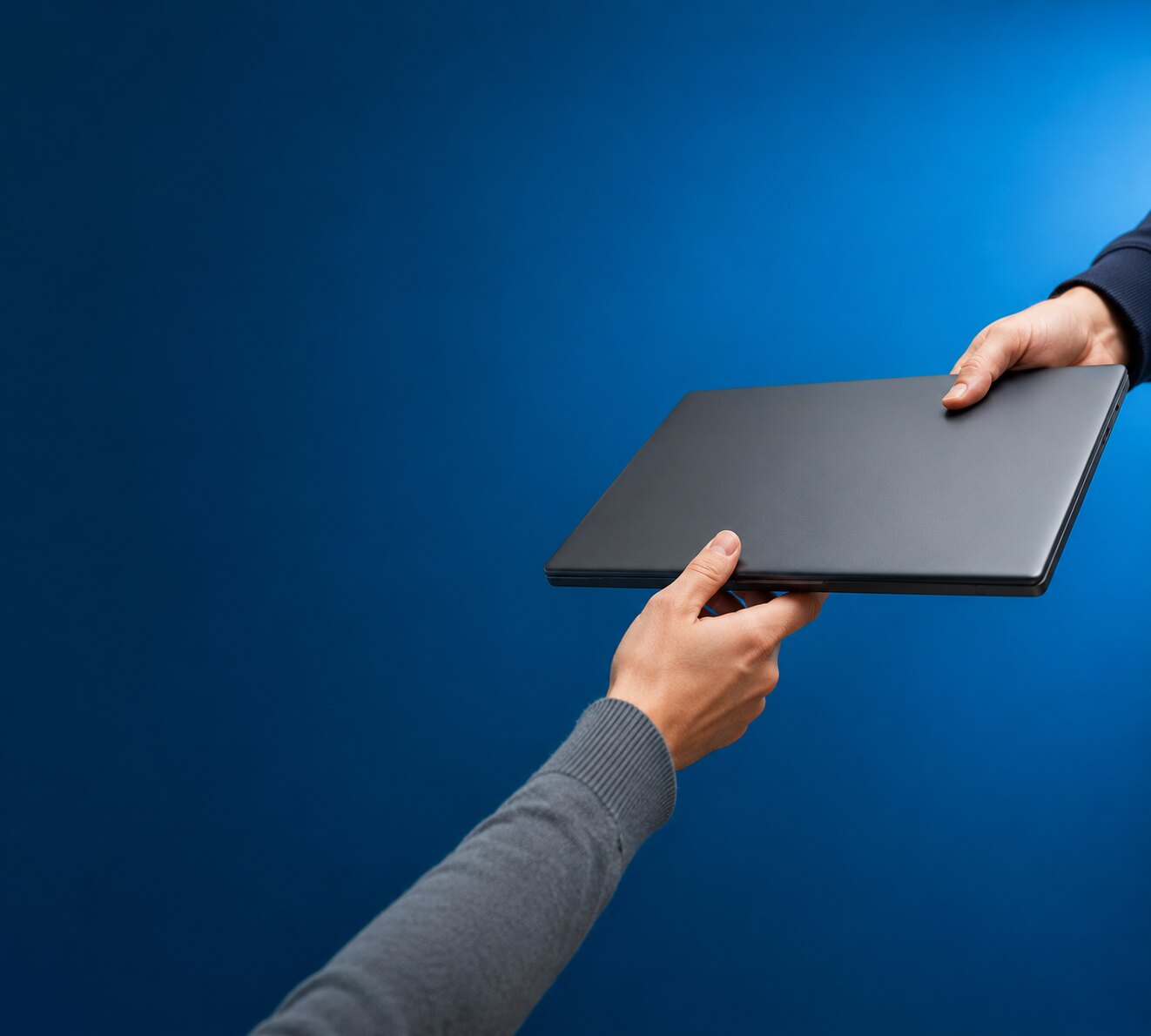Übergabe eines Notebooks vor blauem Hintergrund, Ankauf gebrauchter Hardware bei Top-Hardware